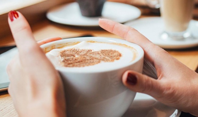 a person holding a cup of coffee